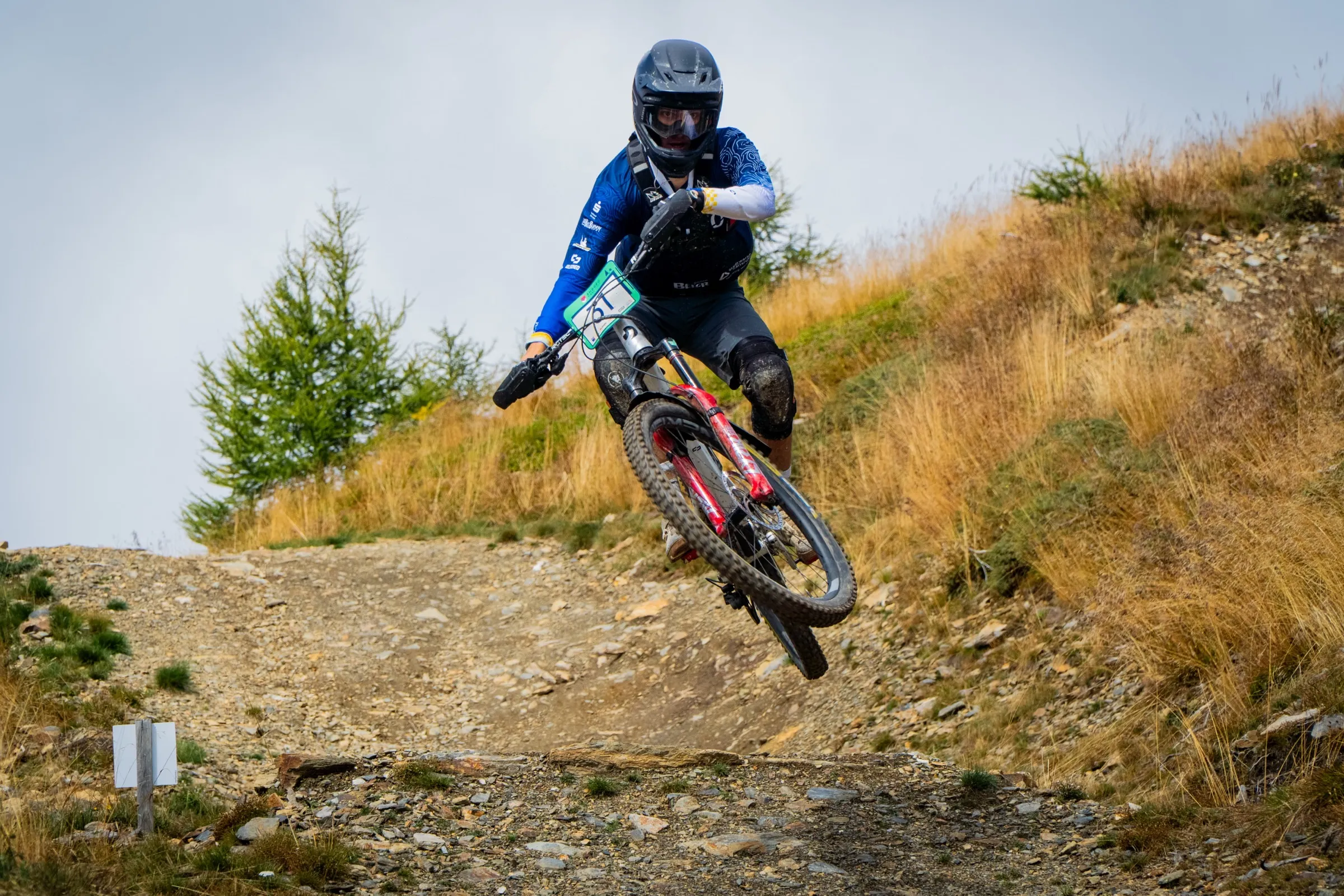 Mountainbiker im Sprung über eine Kuppe auf der Enduro-Strecke